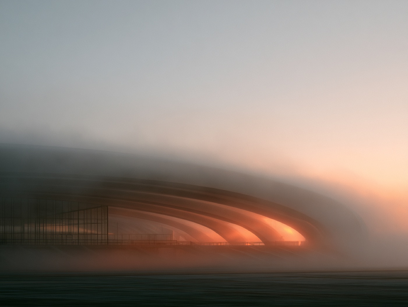 A stadium dissolving into fog at sunrise, warm light held under the roofline